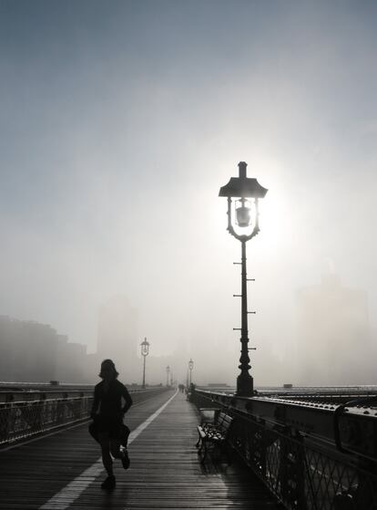 Una mujer corre por las calles de Nueva York bajo una intensa niebla