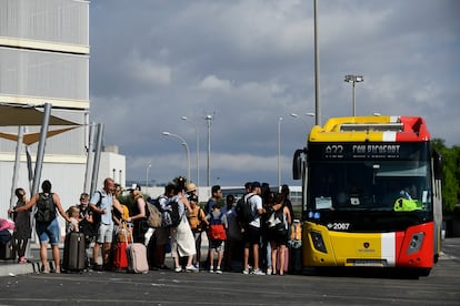 Turistas hacen cola para subir a un autobús, este lunes en el aeropuerto de Palma.