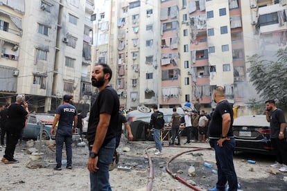 Varias personas inspeccionan el lugar del ataque israelí en un barrio del sur de Beirut, este viernes. 