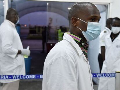 Personal sanitario espera para hacer controles a pasajeros en Costa de Marfil. 