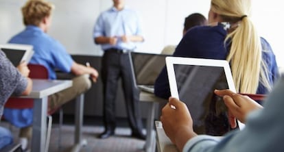 Estudantes usam um tablet em sala de aula.