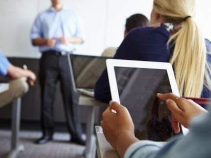 Estudantes usam um tablet em sala de aula.