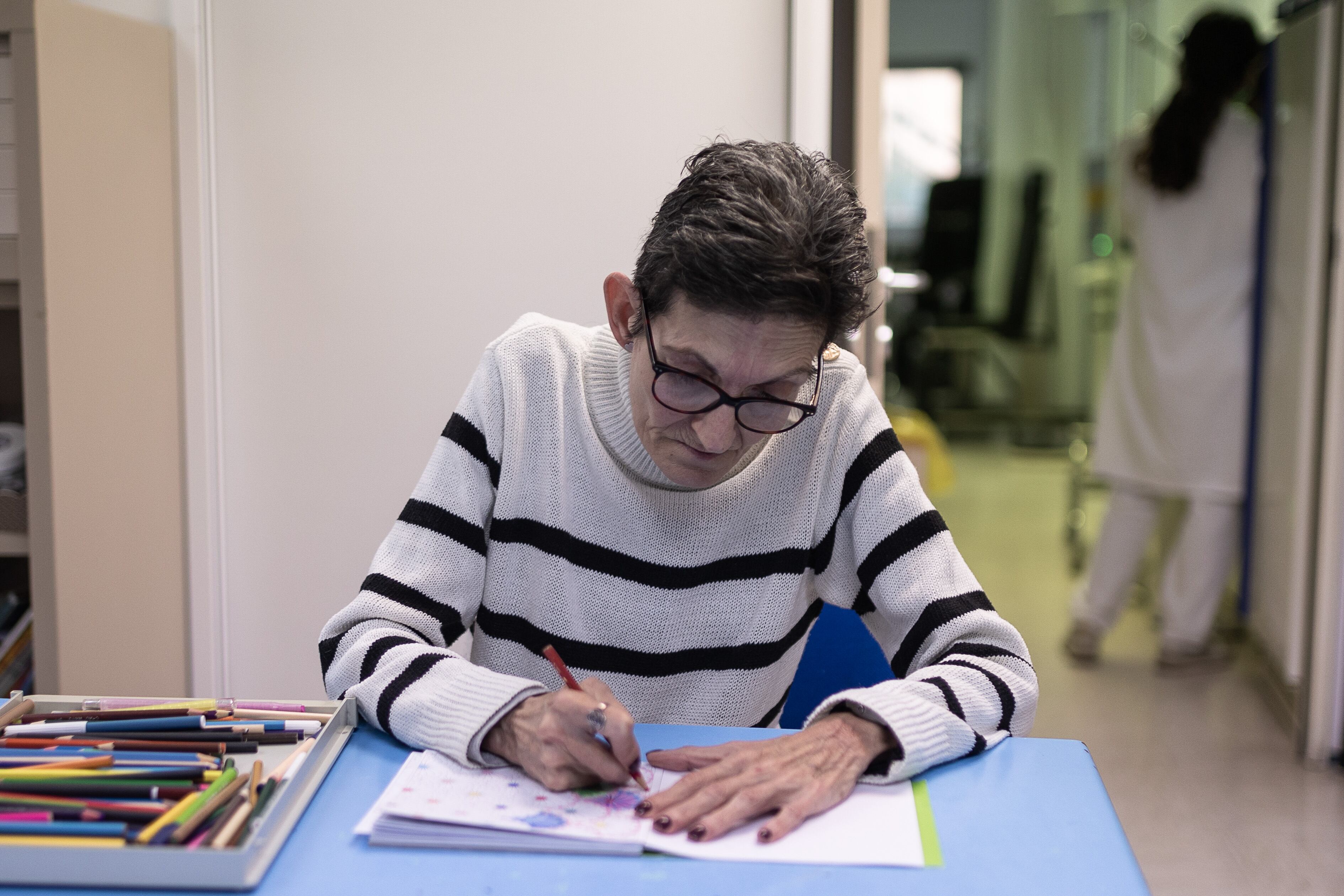 Yolanda, de 55 años, pinta en un libro en el hospital de día de la Unidad de TCA del Sant Pau.