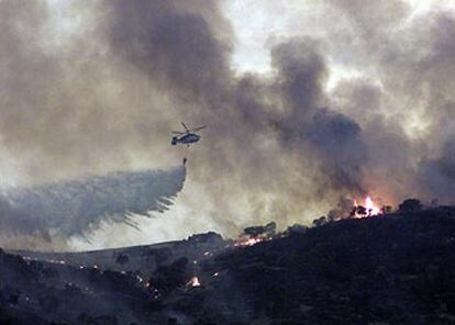 Un helicóptero vierte agua sobre el incendio de ayer en el Castillo de las Guardas.