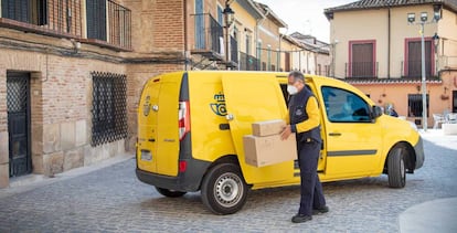 Repartidor de Correos junto a su furgoneta en una zona rural