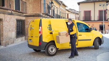 Repartidor de Correos junto a su furgoneta en una zona rural