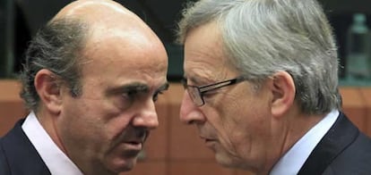 El ministro español de Economía, Luís de Guindos, intercambia miradas con el presidente del Eurogrupo, Jean-Claude Juncker