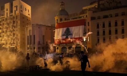 Manifestantes entre gases lacrimogêneos lançados pelas forças de segurança protestam nas proximidades do Parlamento, em Beirute, no sábado.