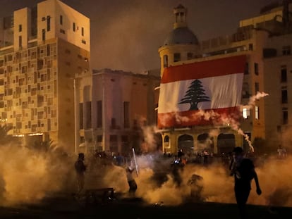 Manifestantes entre gases lacrimogêneos lançados pelas forças de segurança protestam nas proximidades do Parlamento, em Beirute, no sábado.