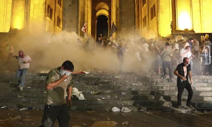 Manifestantes se protegen de una carga de gases lacrimógenos, este viernes en Tblisi.