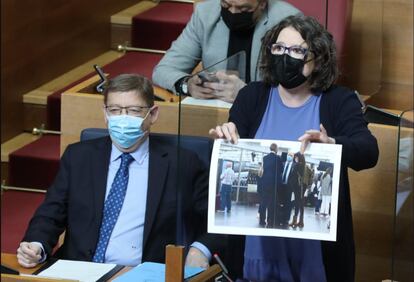 La vicepresidenta de la Generalitat, Mónica Oltra, muestra una imagen de Francisco Camps (de espaldas), con Alberto de Rosa (Ribera Salud) y Cristina Seguí, en las Cortes valencianas.