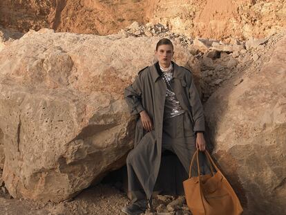 Gabardina y pantalón de lana vaporosa, ambos de Céline. Debajo, abrigo de lana de A.P.C., top de lentejuelas bordado a mano de Blumarine, botas de trabajo de cuero de Blundstone y bolso tamaño grande de cuero de ternero de Céline. La modelo lleva la loción y el sérum Forever Youth Liberator, de YSL Beauté.