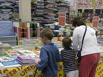 Una familia mira libros de texto en una superficie comercial.
