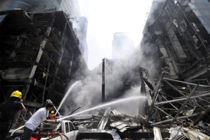 Bomberos tailandeses trabajan en el Central World, el segundo mayor centro comercial de Asia, destruido tras ser incendiado ayer por los <i>camisas rojas</i>.