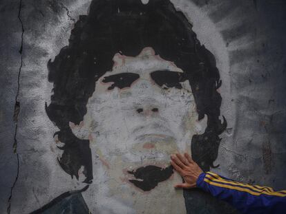 FILED - 25 November 2020, Argentina, Buenos Aires: A fan of the football club Boca Juniors puts his hand on a mural with the picture of the football star Diego Maradona on the day of his death. Argentina football great Diego Maradona has died at the age of 60, the Argentinian Football Association said on Wednesday. Photo: Fernando Gens/dpa
25/11/2020 ONLY FOR USE IN SPAIN