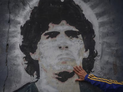 FILED - 25 November 2020, Argentina, Buenos Aires: A fan of the football club Boca Juniors puts his hand on a mural with the picture of the football star Diego Maradona on the day of his death. Argentina football great Diego Maradona has died at the age of 60, the Argentinian Football Association said on Wednesday. Photo: Fernando Gens/dpa
25/11/2020 ONLY FOR USE IN SPAIN
