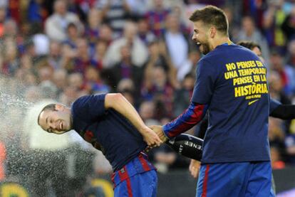 Piqué ducha con champán a Iniesta tras ganar la Liga el domingo en el Camp Nou.