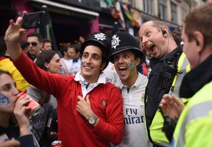 Seguidores del Real Madrid se hacen una foto con un agente de policía en Cardiff.