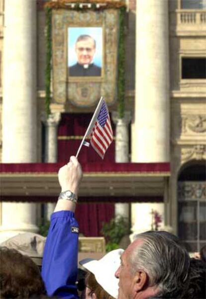 Una asistente a la canonización de Escrivá de Balaguer, en octubre del año 2002, enarbola una bandera de EE UU.