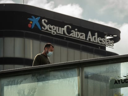 Un transeúnte pasa ante la sede de SegurCaixa Adeslas en Barcelona, el pasado abril.