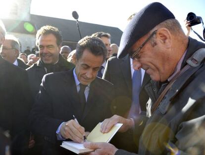 El presidente francés, Nicolas Sarkozy, firma un autógrafo.