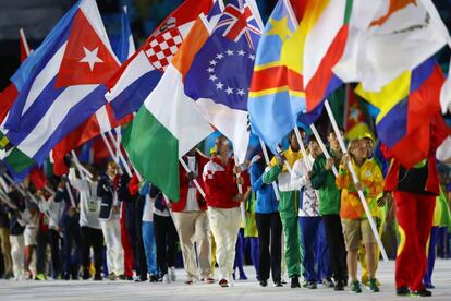 Atletas levam as bandeiras dos países participantes da Olimpíada.