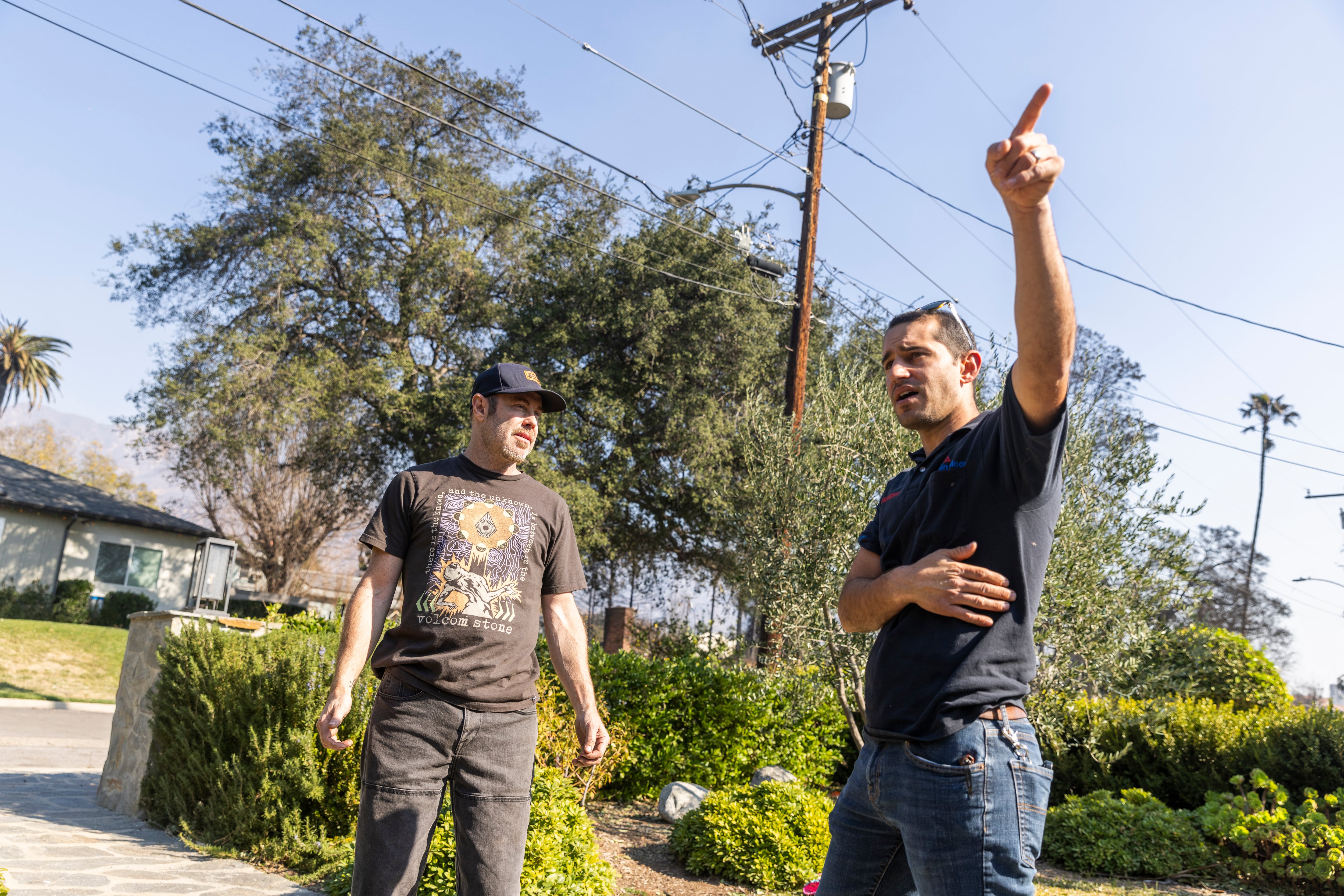 Shane Jordan (con gorra) y su vecino Rob, cuya casa salvó del fuego, charlan por primera vez tras el incendio, en Altadena.