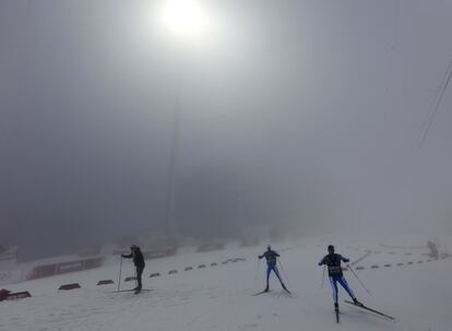 Los miembros del equipo italiano de esquí antes del inicio de 15 kilometros de biatlón en los Juegos Olímpicos de Invierno de Sochi 2014 en Rosa Khutor. La carrera se retrasó debido a las condiciones meteorológicas de niebla.