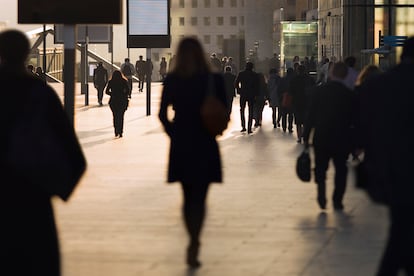 Silhouette of businesswoman among other commuters at modern business district