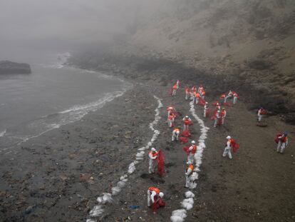 Un grupo de trabajadores limpia Playa Cavero, en el distrito de Ventanilla de Callao (Perú), después del derrame de petróleo, el 15 de febrero de 2022.
