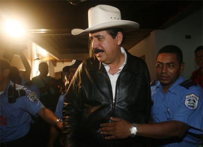 El depuesto presidente Manuel Zelaya es escoltado por policías tras una conferencia de prensa en la Embajada de Honduras en Managua.