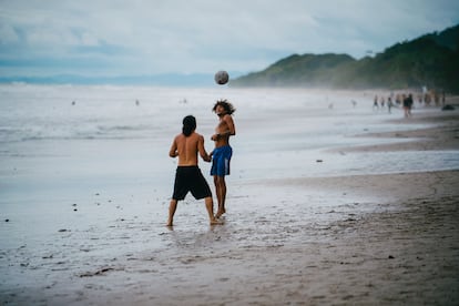 Dos hombres juegan al fútbol en la playa de Santa Teresa.