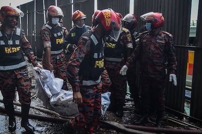 Los bomberos rescatan cuerpos de víctimas tras el incendio en una fábrica de Bangladés, este viernes.