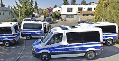 Coches de polic&iacute;a permanecen aparcados ante la residencia del sospechoso detenido por el atentado contra el autob&uacute;s del Dortmund en Rotemburgo, cerca de Tubinga (Alemania).