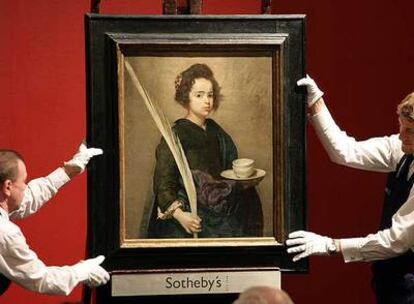 Dos operarios sostienen el cuadro &#39;Santa Rufina&#39;, atribuido a Diego de Velázquez, en la subasta de la casa Sotheby&#39;s de Londres en 2007.