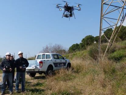 Unos operarios de Endesa supervisan los trabajos de comprobación de un dron.
