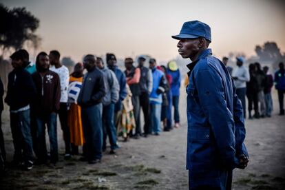 Un oficial de policía controla el acceso a uno de los colegios electorales durante la jornada de votación en Mbare (Zimbabue).