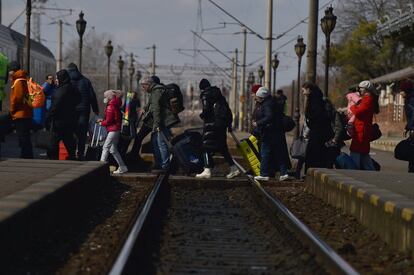 Refugiados cruzan las vías del tren de la estación Suceava de Bucarest (Rumania) tras huir de Ucrania, este jueves.