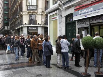 Gente haciendo cola para hacerse con un décimo de lotería de Navidad de la administración de loterías Doña Manolita