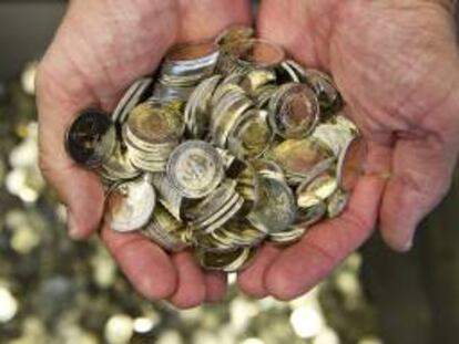 Un hombre sostiene varias monedas de euro. EFE/Archivo