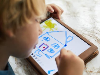 Un niño se entretiene mientras dibuja en una tableta.