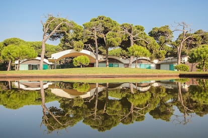 Fachada principal de La Ricarda, de Antonio Gomis, ente los pinos y reflejada en el estanque.