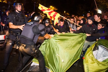 Los mossos d'esquadra desmontan el despliegue de varias tiendas de campaña que un centenar de personas había plantado ante la Delegación del Gobierno en Cataluña, en protesta por la suspensión cautelar de la Ley de Consultas y la convocatoria del referéndum del 9 de noviembre.