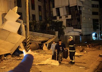 Dos personas son escoltadas por un bombero tras ser rescatadas del Hotel Marshal en Hualien (Taiwán), el 6 de febrero de 2018.