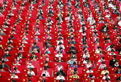 Estudiantes de primaria sostienen la bandera china durante la celebración del Día Nacional, en la provincia de Sichuán.