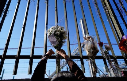 Una persona deja un ramo de flores en una de las vallas cercanas a la estación de Atocha durante el 15 aniversario de los atentados del 11-M, en Madrid.