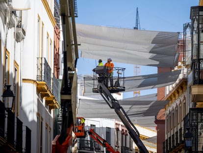 Operarios trabajan en la colocación de toldos para aliviar el calor en el centro de Sevilla, el 10 de abril.