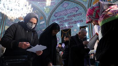 Iraníes consultan las papeletas de los candidatos en un colegio electoral de Teherán, el 1 de marzo de 2024.