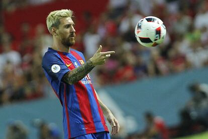 Messi lanza un balón con la mano.