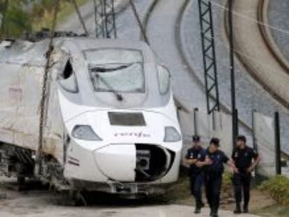  Efectivos de la polic&iacute;a custodian la locomotora del tren Alvia que el pasado mi&eacute;rcoles descarril&oacute; en las inmediaciones de Santiago, antes de ser trasladada a Escravitude, en Padr&oacute;n (A Coru&ntilde;a), a una zona custodiada por la Polic&iacute;a Nacional. EFE/Lavandeira jr